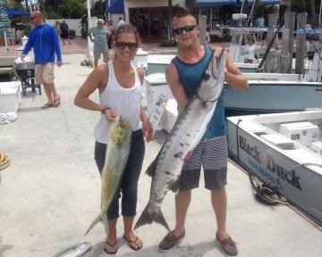 man and woman posing with some caught fish
